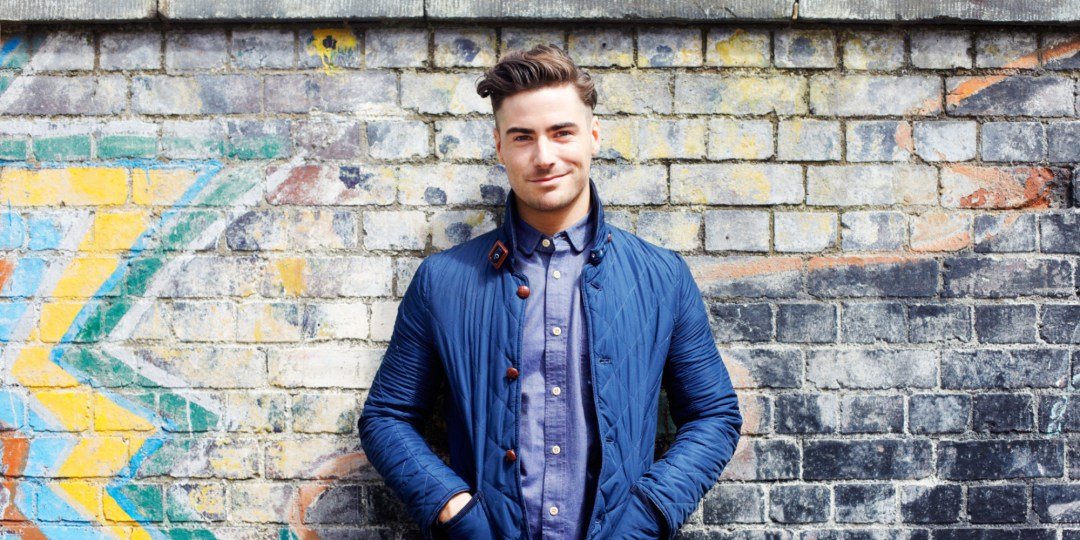 Portrait of young man against wall.